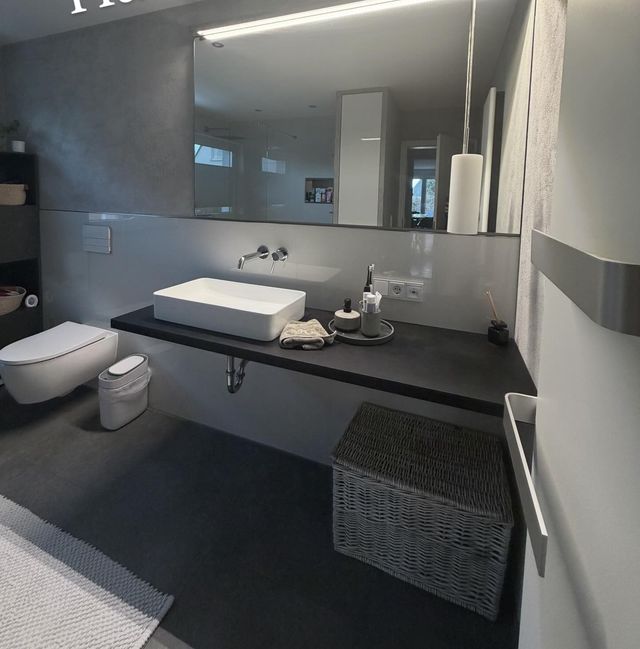 Modernes Badezimmer mit Waschtisch und großem Spiegel