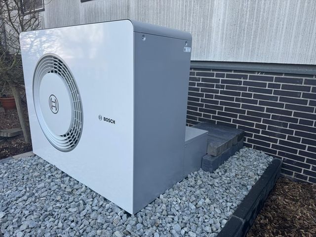 Außeneinheit einer neu installierten Wärmepumpe an der Hauswand