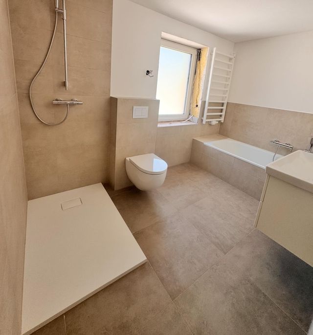 Fertig saniertes Badezimmer mit bodengleicher Dusche und Badewanne