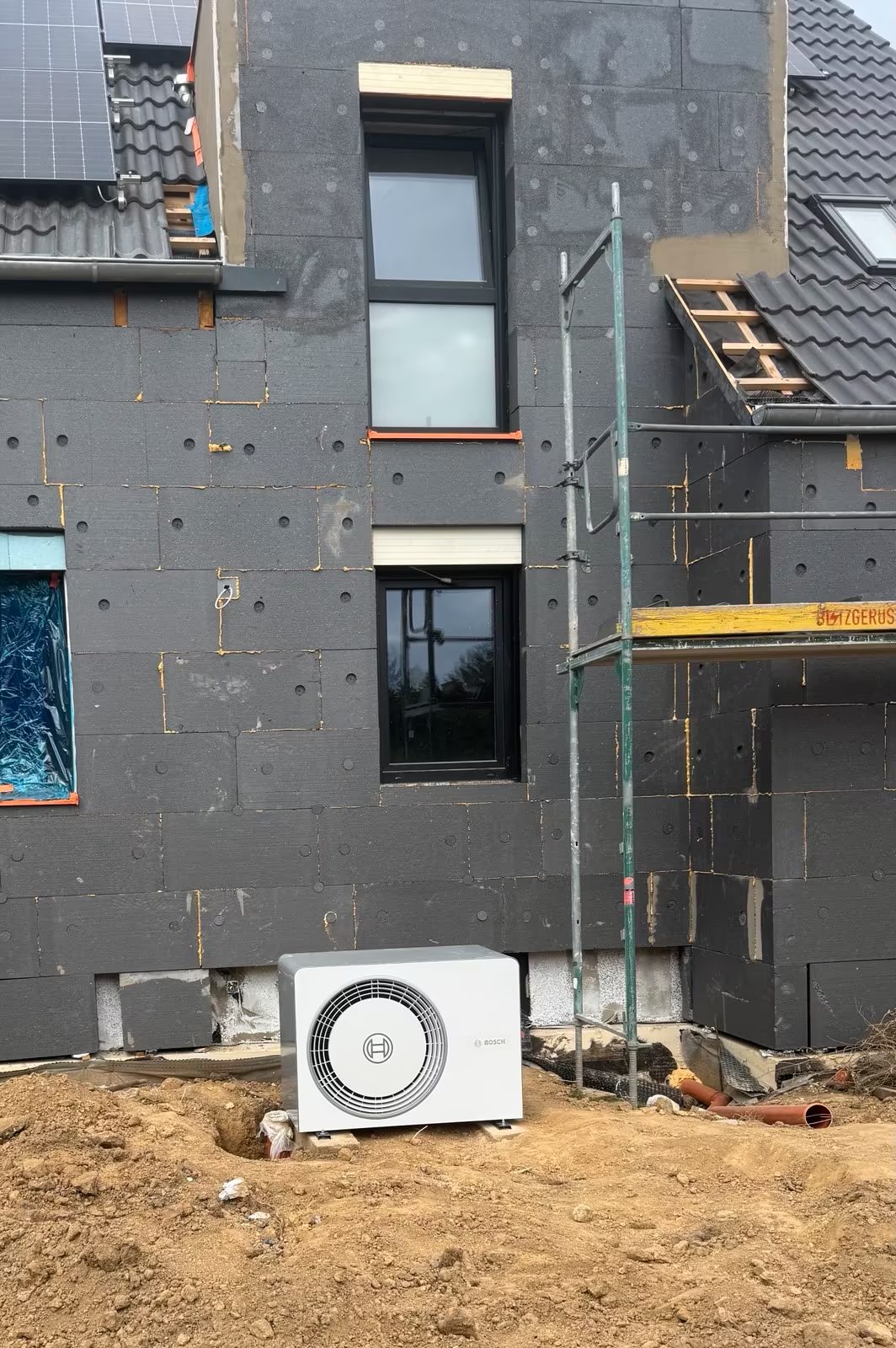 Neubau im Rohbauzustand mit installierter Haustechnik an der Fassade