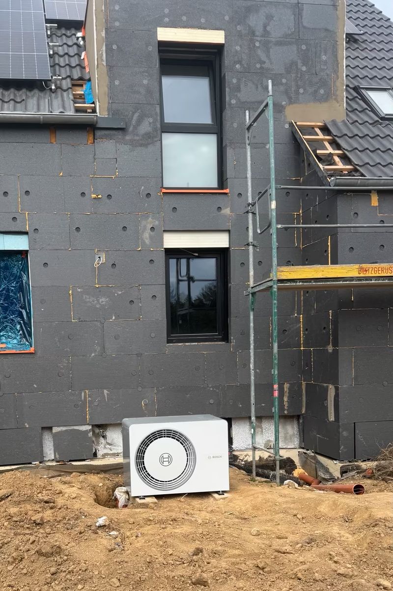 Wärmepumpe an einem Neubau mit Gerüst